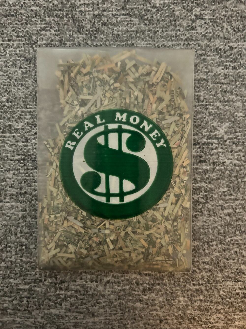 Real Money shredded currency bag with green dollar sign logo